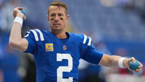 Colts quarterback Matt Ryan warms up with medicine balls before a game.
